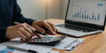 Person calculating student loan payments with documents and laptop