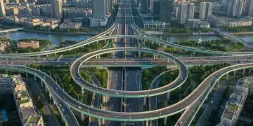 Modern highway interchange with green streetlights and urban landscape